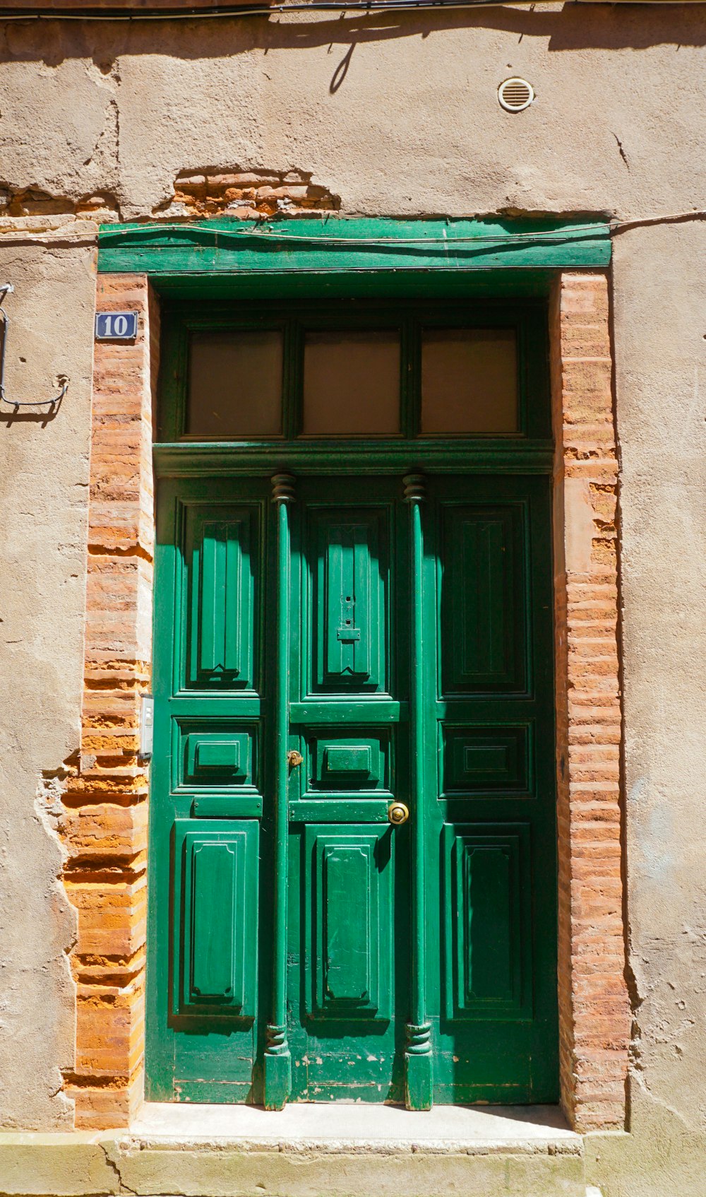 green wooden door on brown concrete building