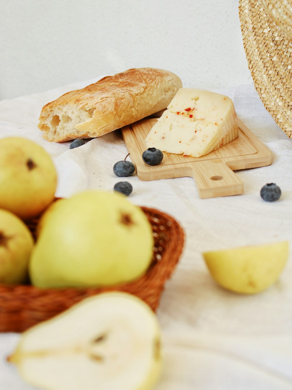 green apple fruit beside bread on brown wooden table