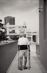 A senior using a sleek walking aid with built-in technology on a sunny sidewalk.