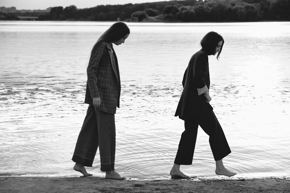 man and woman walking on beach during daytime