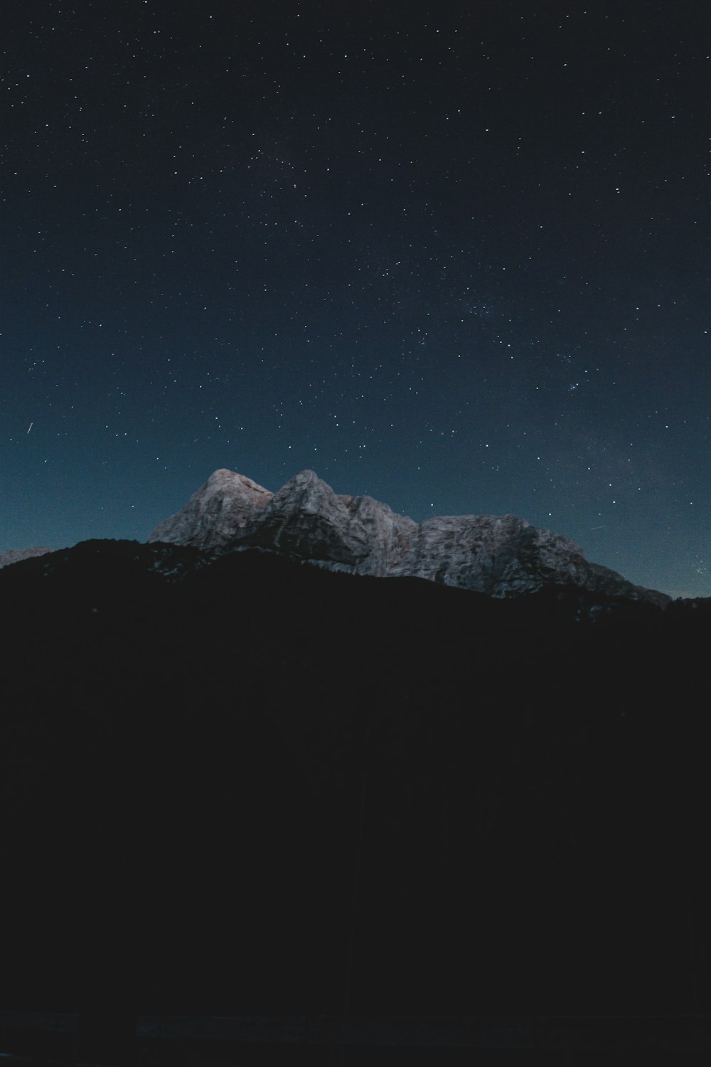 snow covered mountain under blue sky during night time