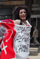 Portrait of a smiling young Nigerian woman holding a banner supporting Peter Obi and Rabiu Kwankwaso.