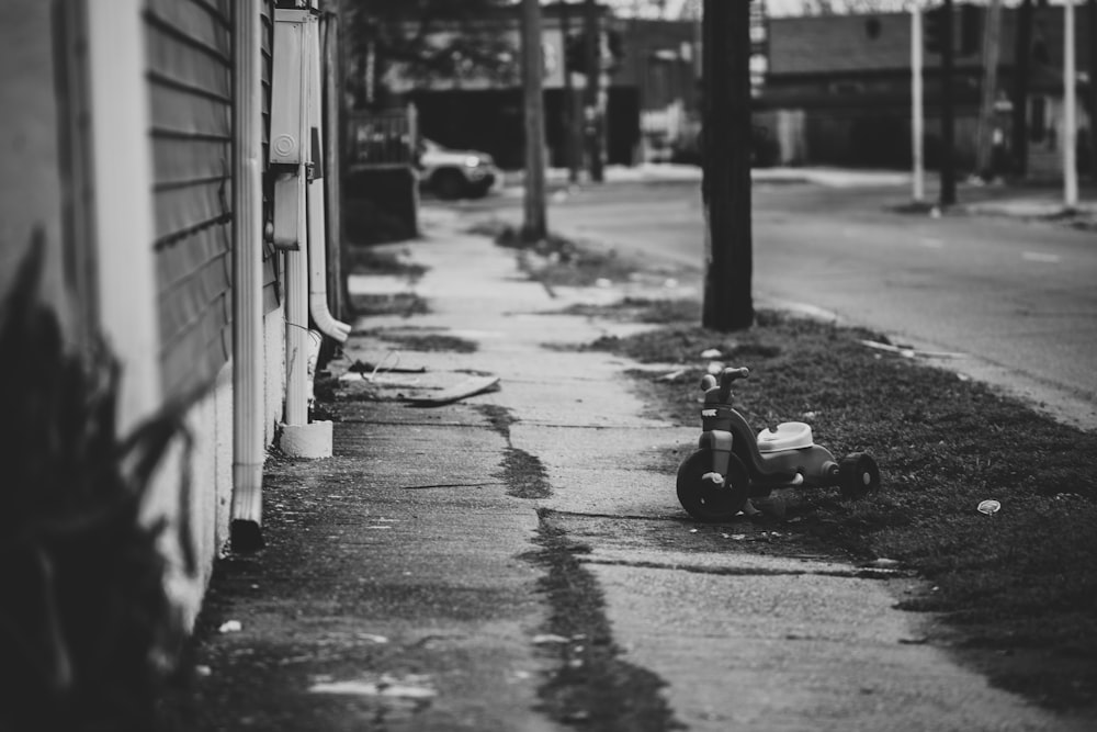 grayscale photo of a ride on toy car on the street