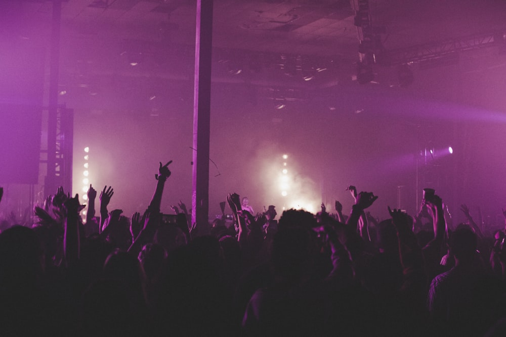 people raising their hands in front of stage