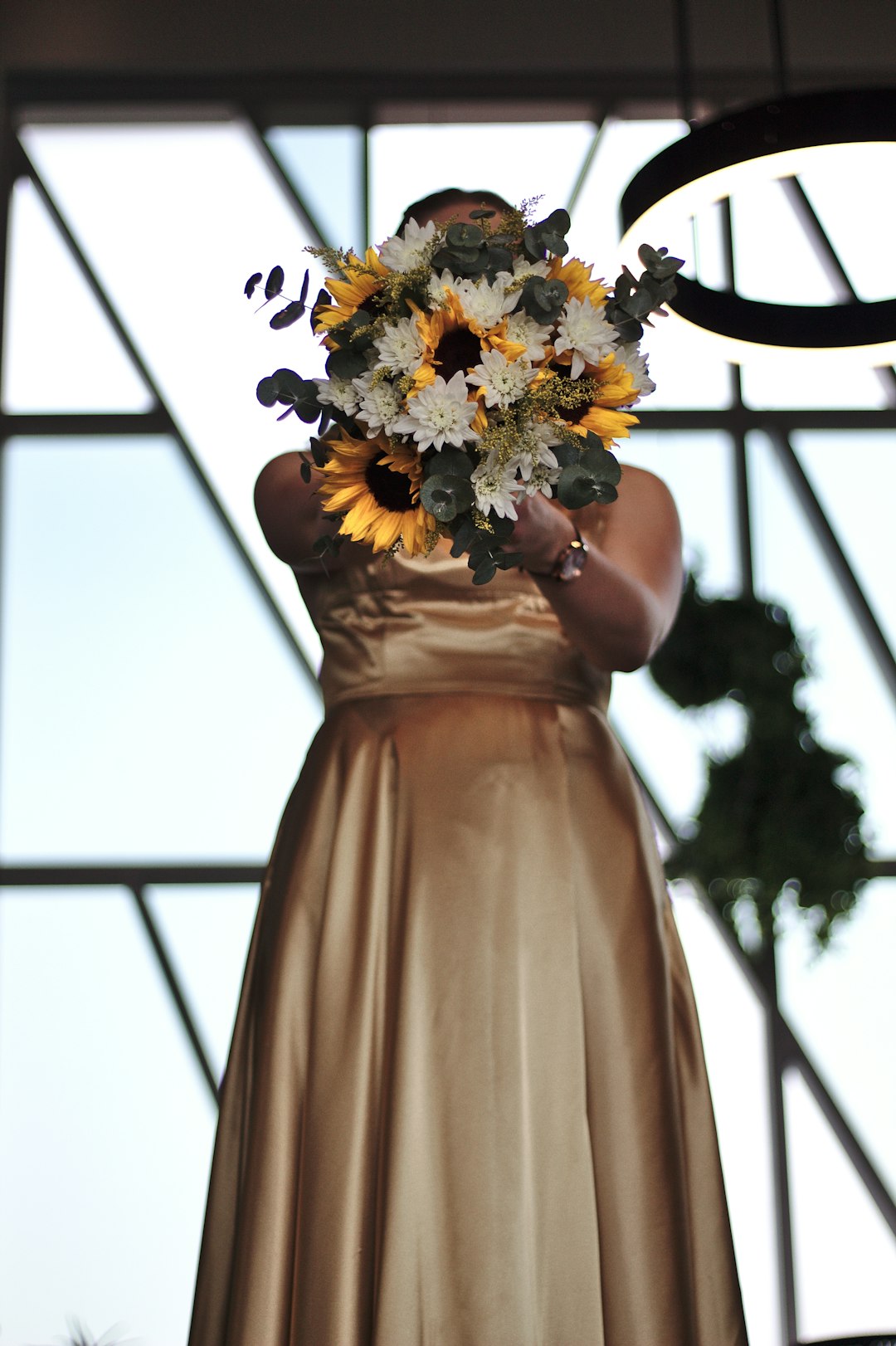 woman in brown dress holding bouquet of flowers