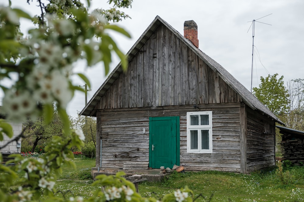 brown wooden house on green grass field during daytime