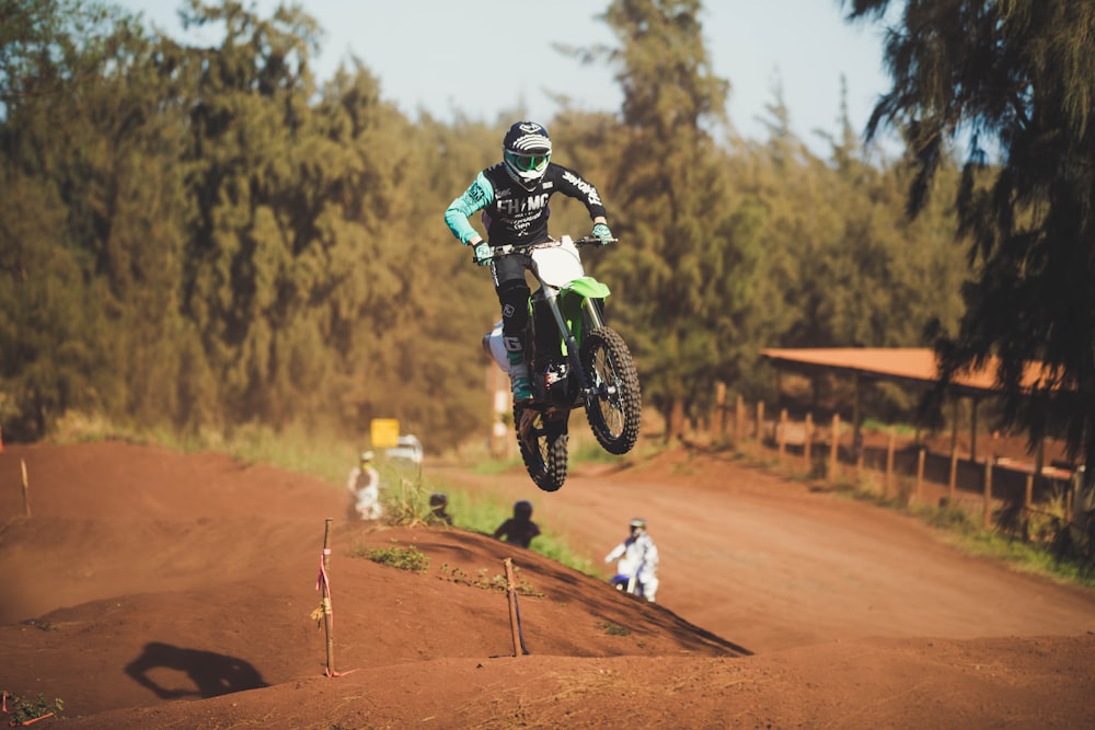 man in green motocross suit riding motocross dirt bike