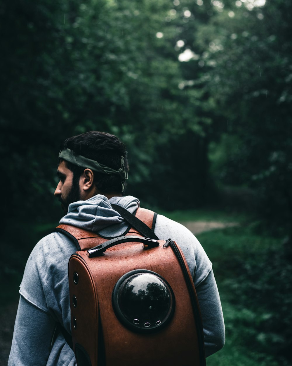 Mann in grauem Hoodie und braunem Rucksack