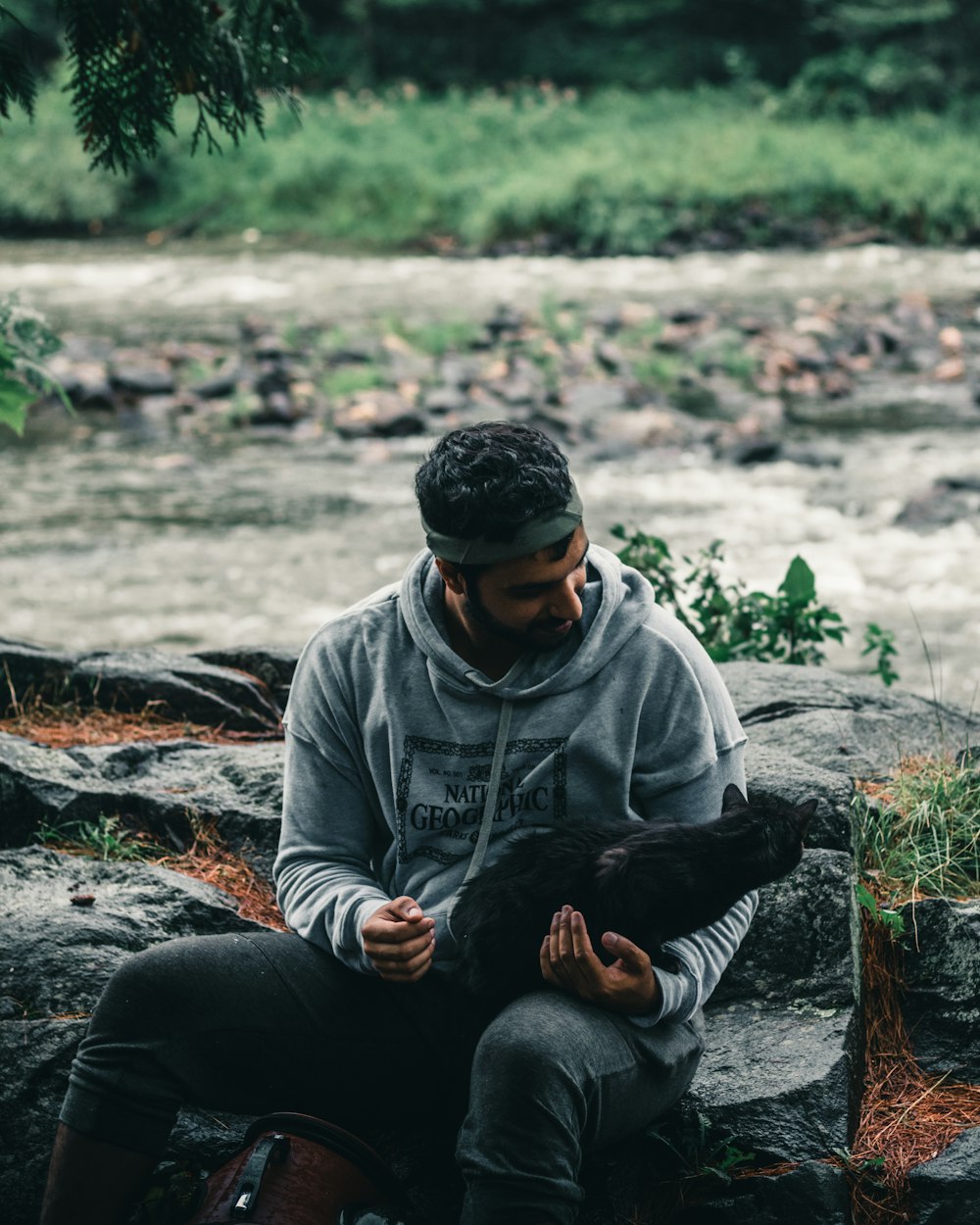 man in gray hoodie and black pants sitting on ground