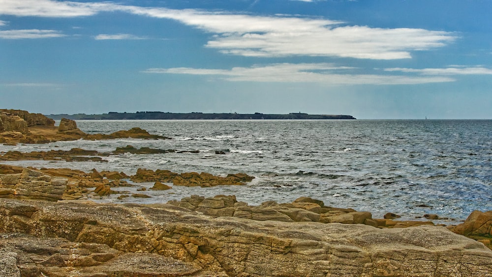 brown rocky shore under blue sky during daytime