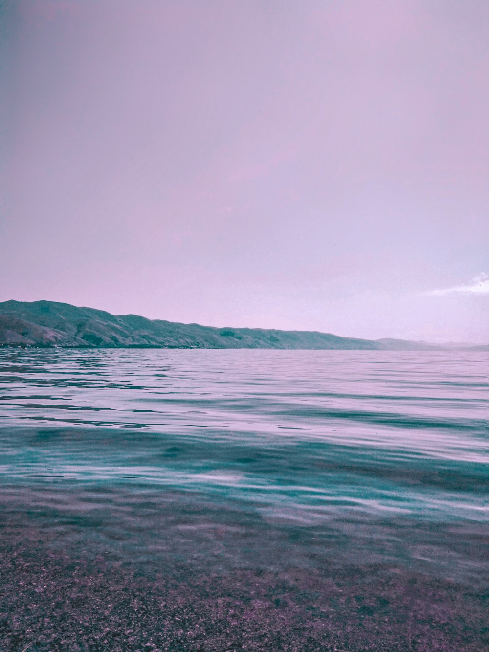 body of water near mountain during daytime