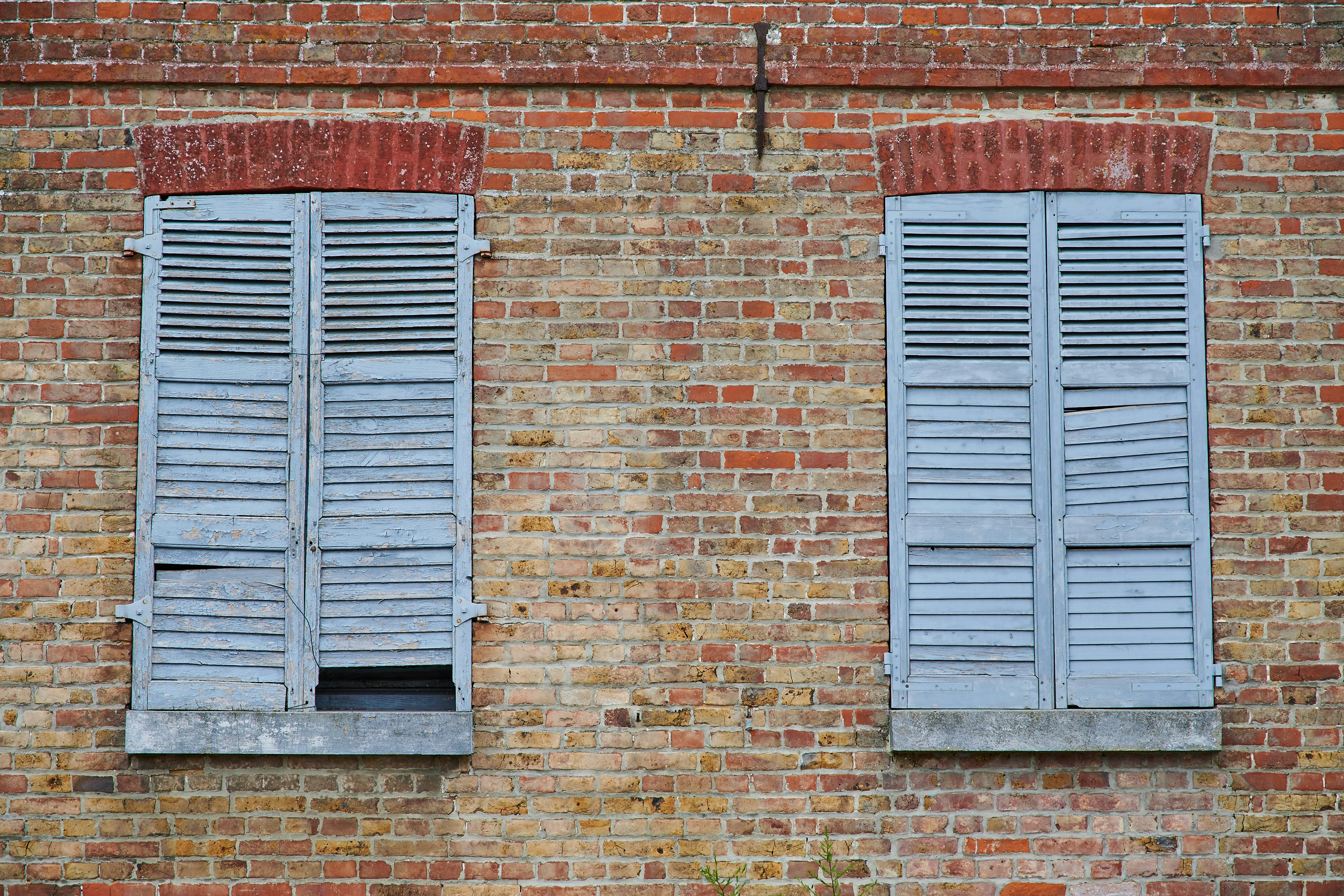 blue wooden window on brown brick wall