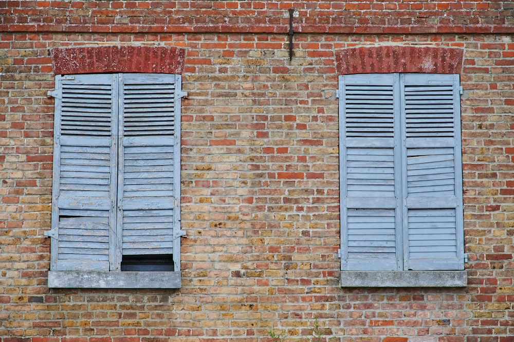 blue wooden window on brown brick wall