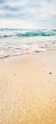 sea waves crashing on shore during daytime