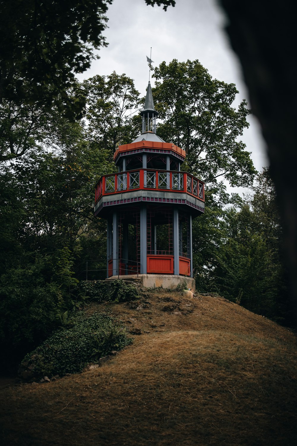 Bâtiment en béton rouge et bleu entouré d’arbres verts pendant la journée