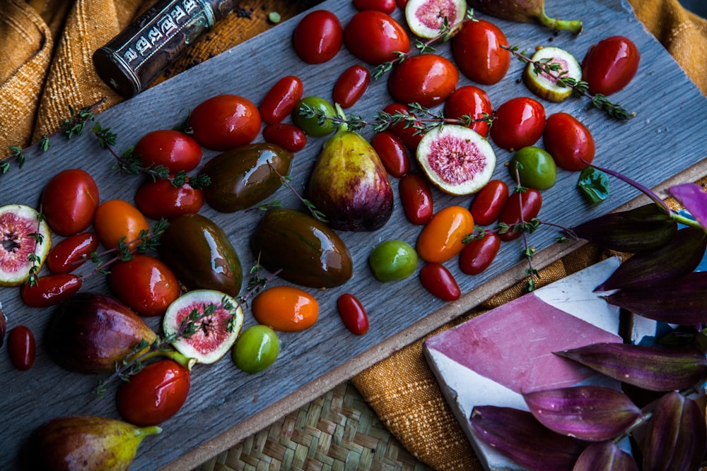 red and green round fruits on brown woven table