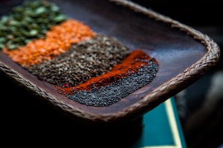 A close-up of vibrant, colorful spices arranged neatly on a wooden surface.