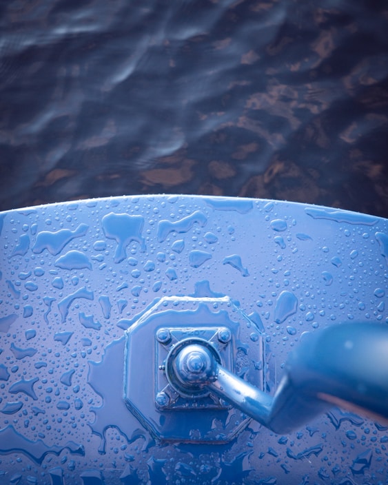 Close-up of a hand holding a bright red water bucket with a comfortable grip handle.
