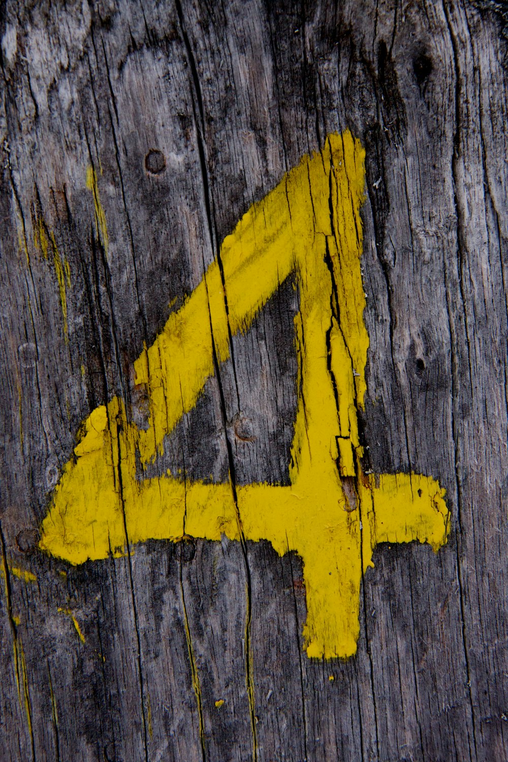 a wooden sign with a yellow arrow painted on it