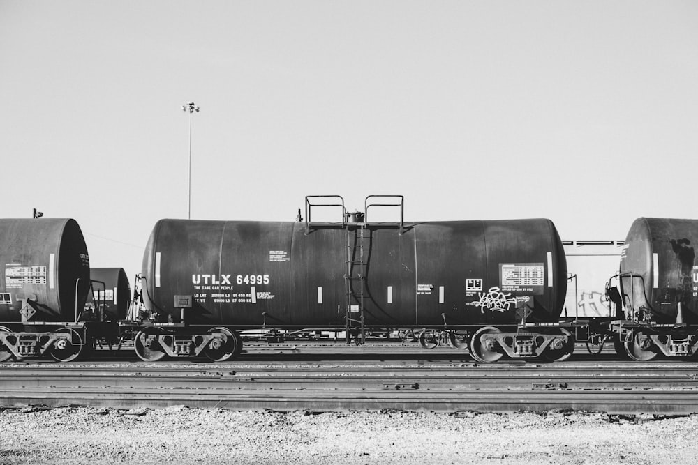 Foto in scala di grigi del treno sui binari ferroviari