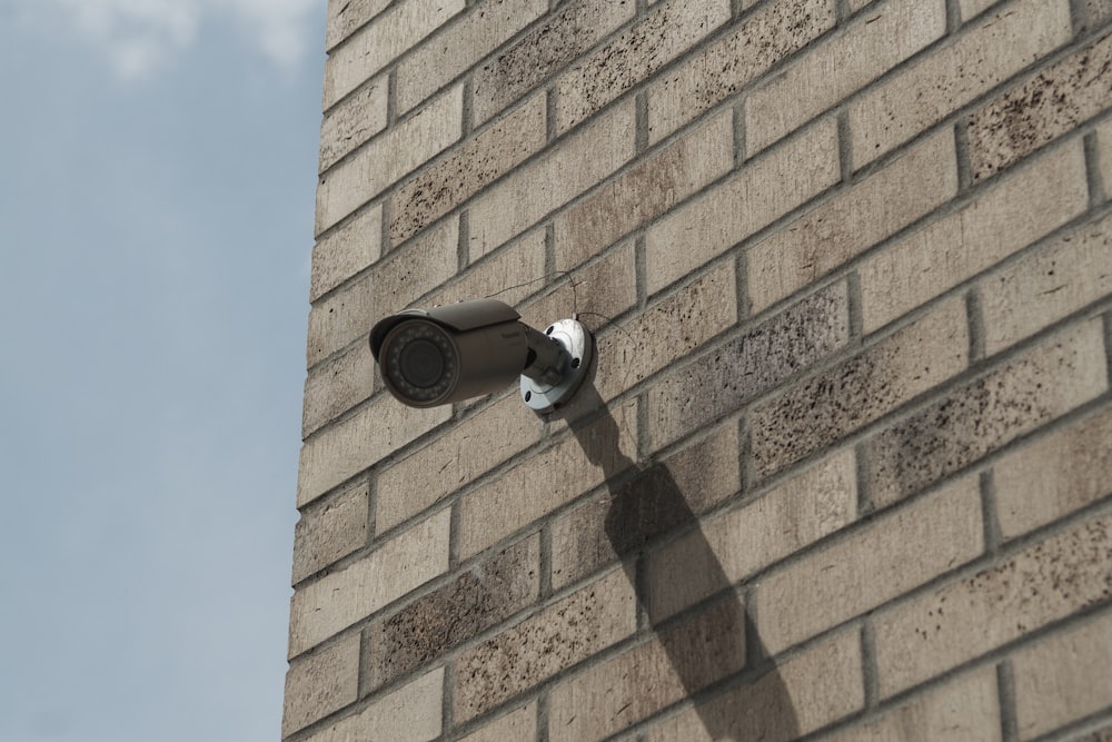 a security camera on the side of a brick building