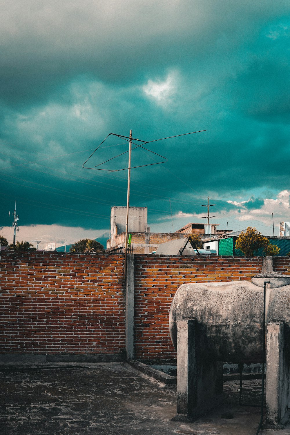 muro di mattoni marroni con mulino a vento bianco sotto il cielo blu durante il giorno