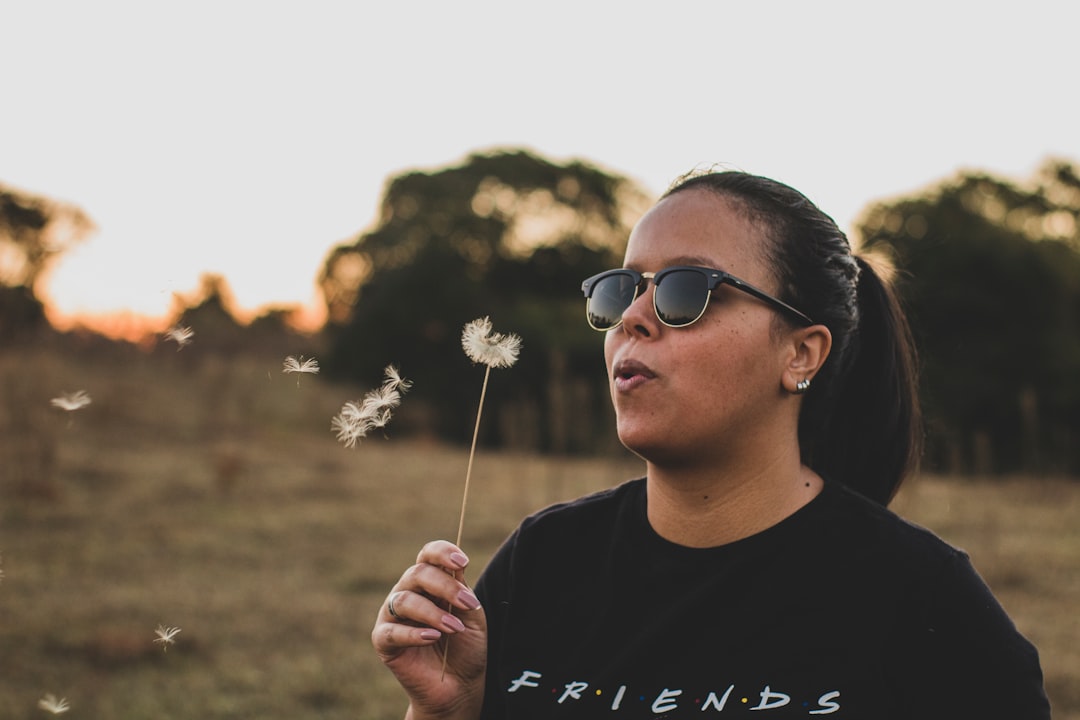 man in black crew neck shirt holding white flower during daytime