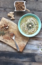 Close-up of vibrant green moringa powder in a wooden bowl on a rustic table.