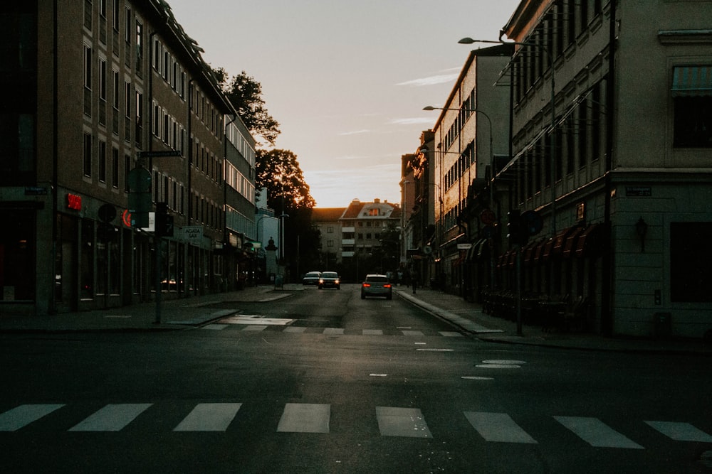 cars parked on the side of the road in between buildings