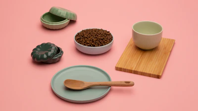 Minimalist luxury decor items displayed on a pastel pink and cream background.