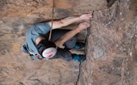 Close-up of a climber gripping a rocky cliff during a via ferrata route.
