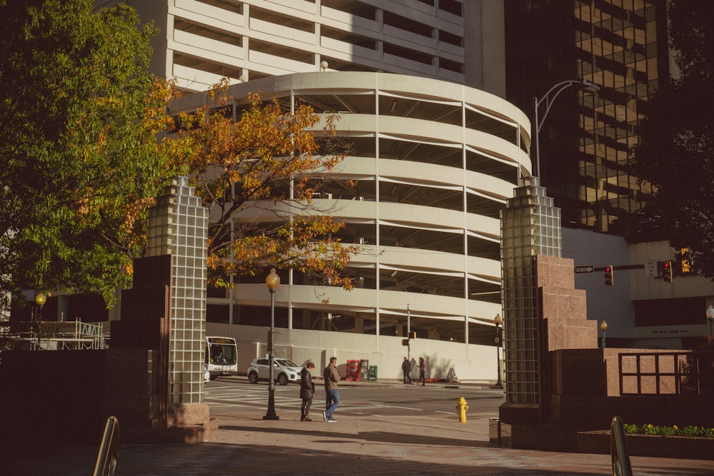 people walking on sidewalk near white concrete building during daytime