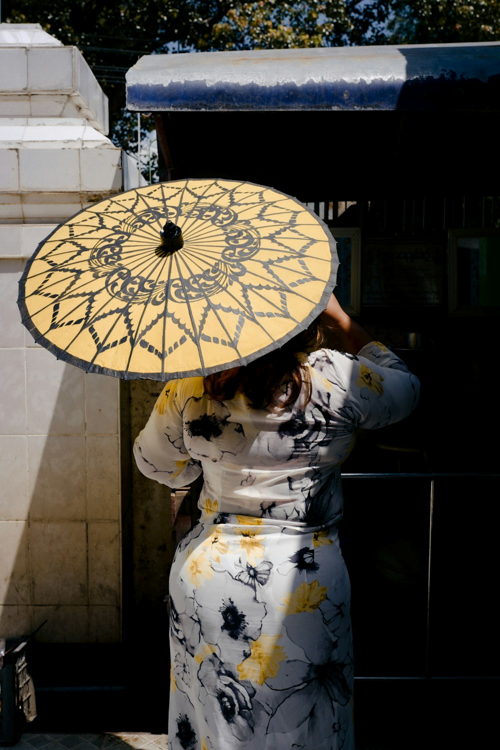 woman in white and yellow floral kimono holding white and yellow floral umbrella