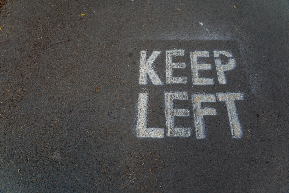 a sign that says keep left on the ground
