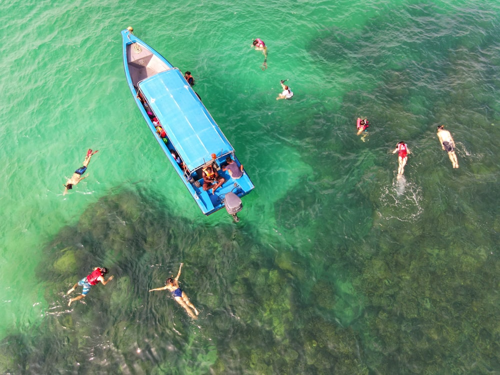 people in blue and white boat on body of water during daytime