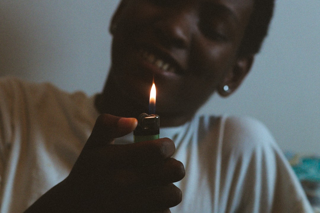 man in white shirt holding green disposable lighter