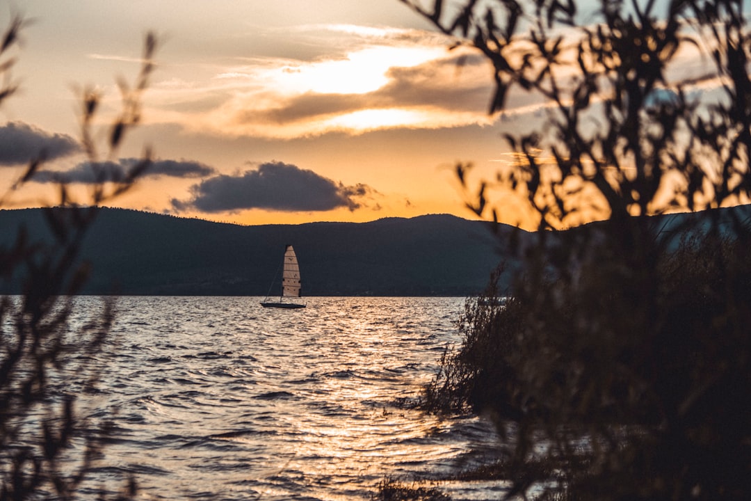 silhouette of mountain near body of water during sunset