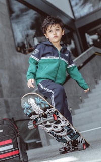 boy in green and blue zip up jacket riding on red and black motorcycle
