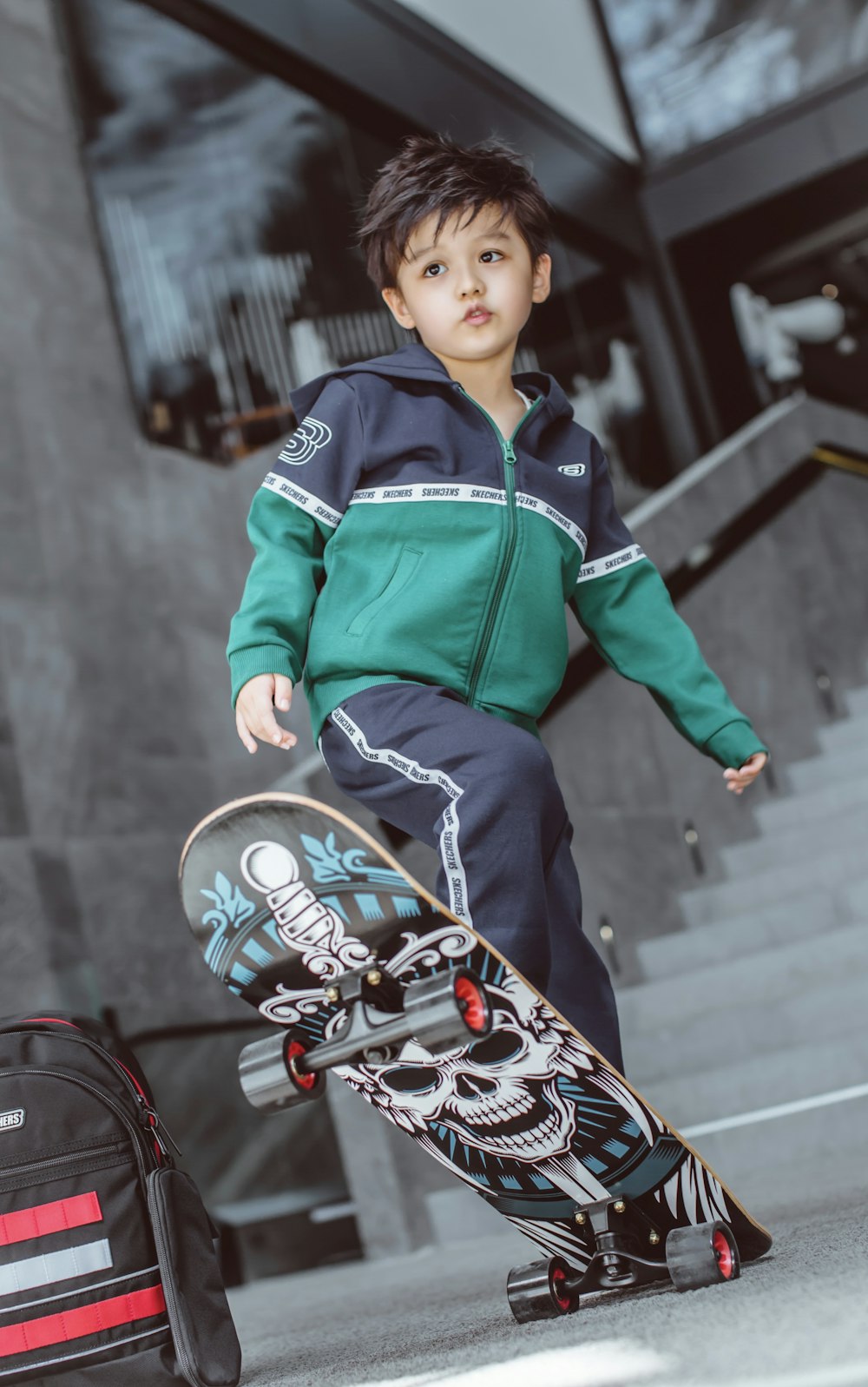 boy in green and blue zip up jacket riding on red and black motorcycle