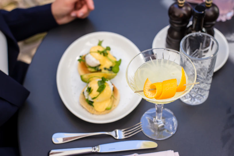 Close-up of a vibrant tropical brunch plate with fresh avocado, poached eggs, and colorful fruit garnish.