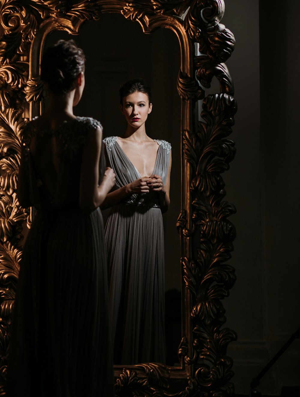 woman in white dress standing beside brown wall