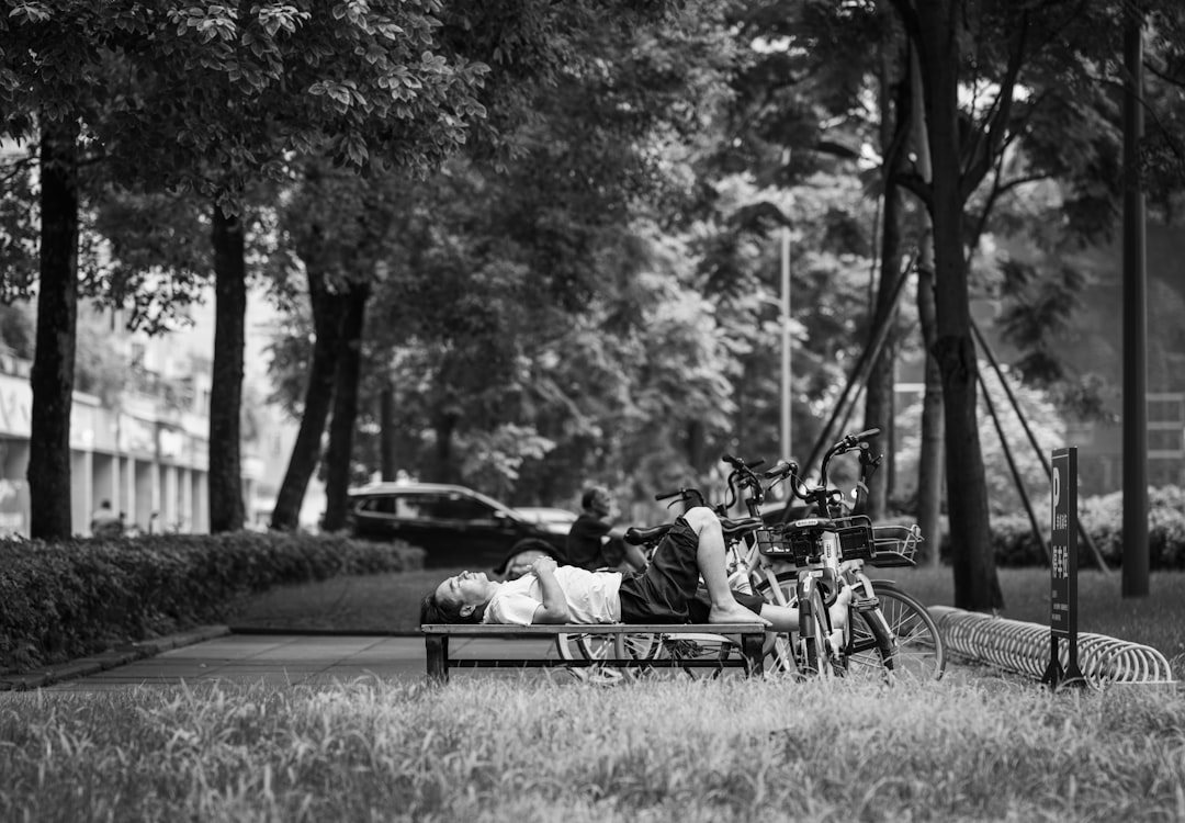 grayscale photo of couple sitting on bench