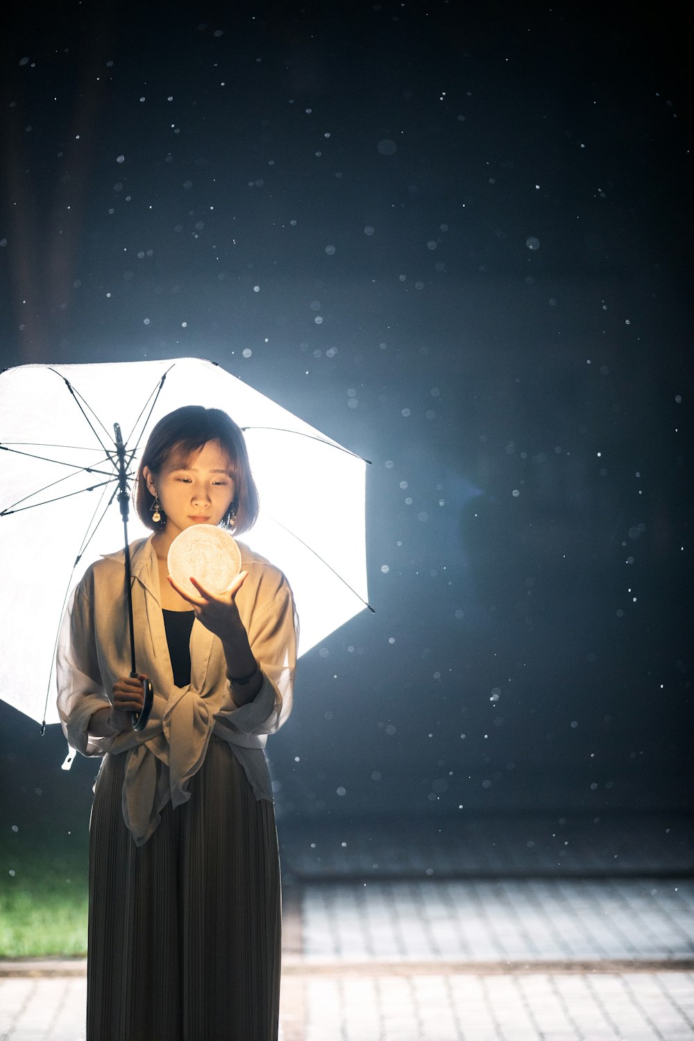 Femme en robe noire tenant un parapluie