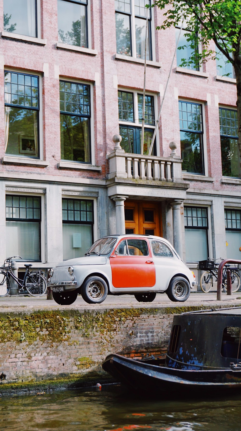 orange and white car parked beside black motorcycle during daytime