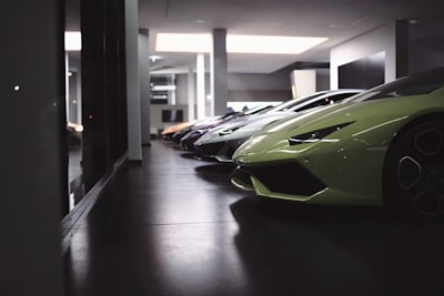 green and black sports car parked in building expensive teams background