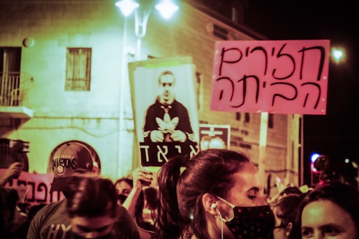 A determined crowd holding signs demanding Rafael León Segovia's release at sunset.