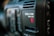 Close-up of a professional video camera, showcasing the EOS C300 Mark III model insignia. The focus is on the branding, with partial views of buttons and controls in the blurred background.