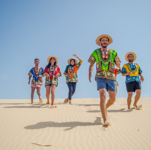 group of people running on brown sand during daytime