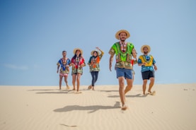 group of people running on brown sand during daytime