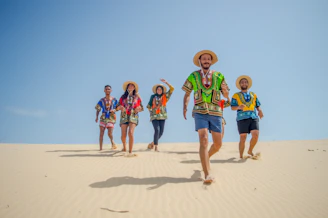 group of people running on brown sand during daytime